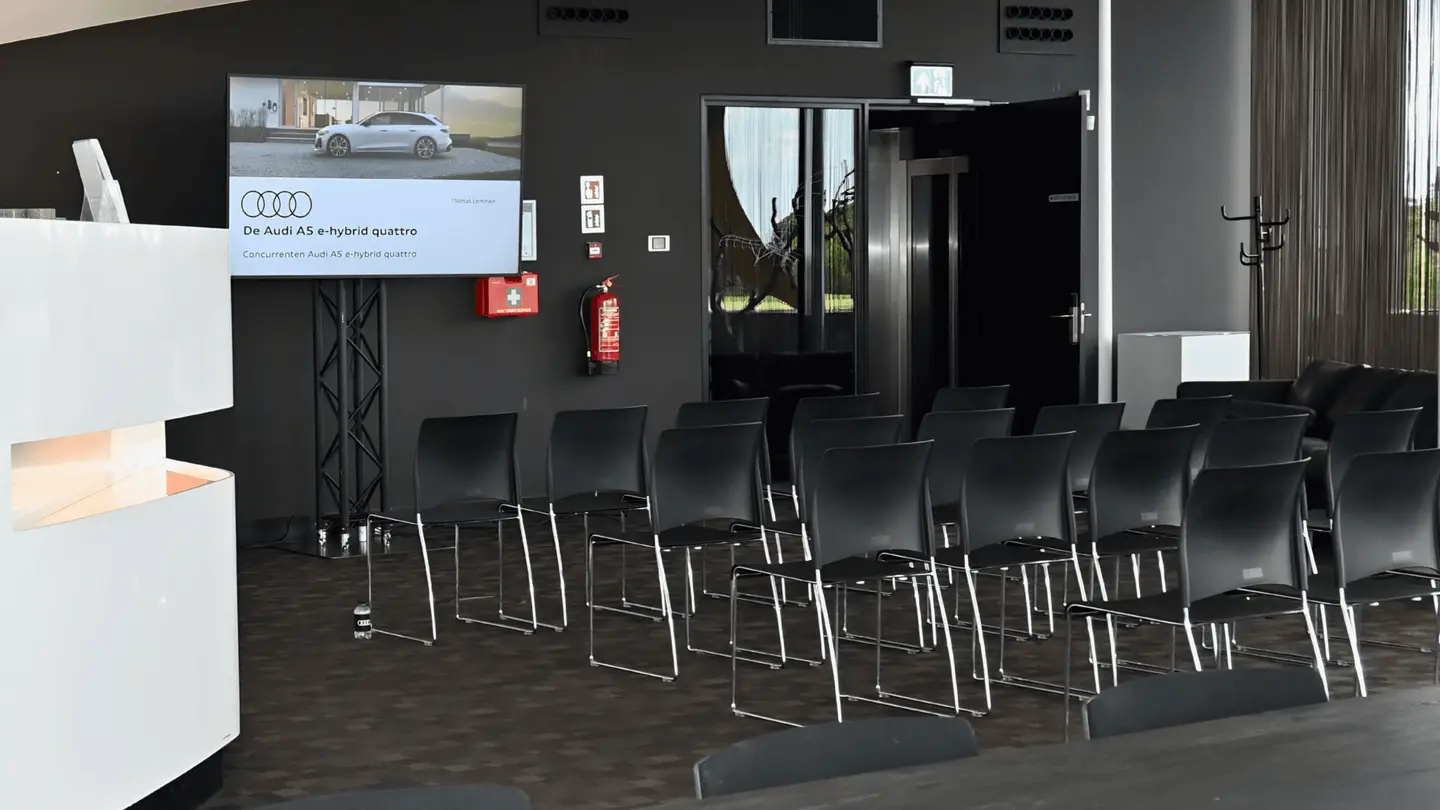 Sky Lounge met stoelen in theateropstelling en een scherm met Audi-presentatie