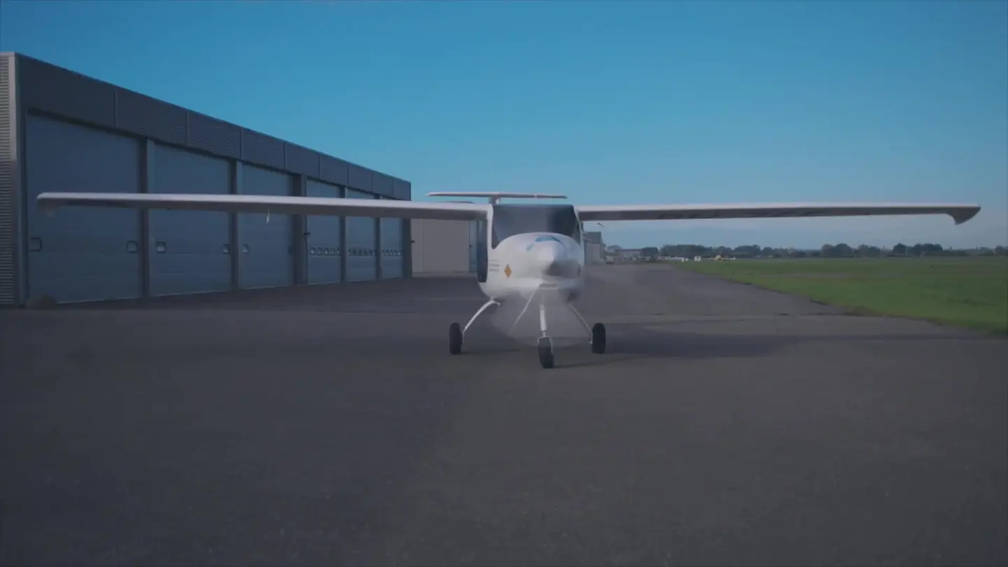 Elektrisch vliegtuig taxiet over het platform langs de hangars van Teuge
