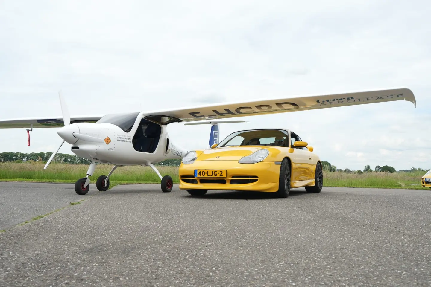 De Pipistrel Velis Electro naast een Porsche in Speedgelb.
