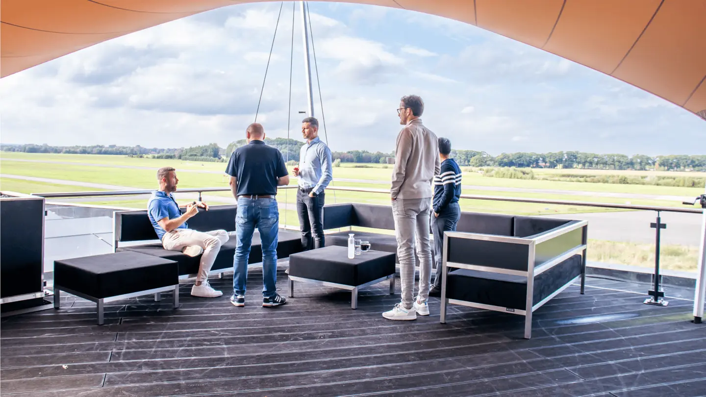 Groep op het overdekte dakterras van de Sky Lounge met lounge-meubels
