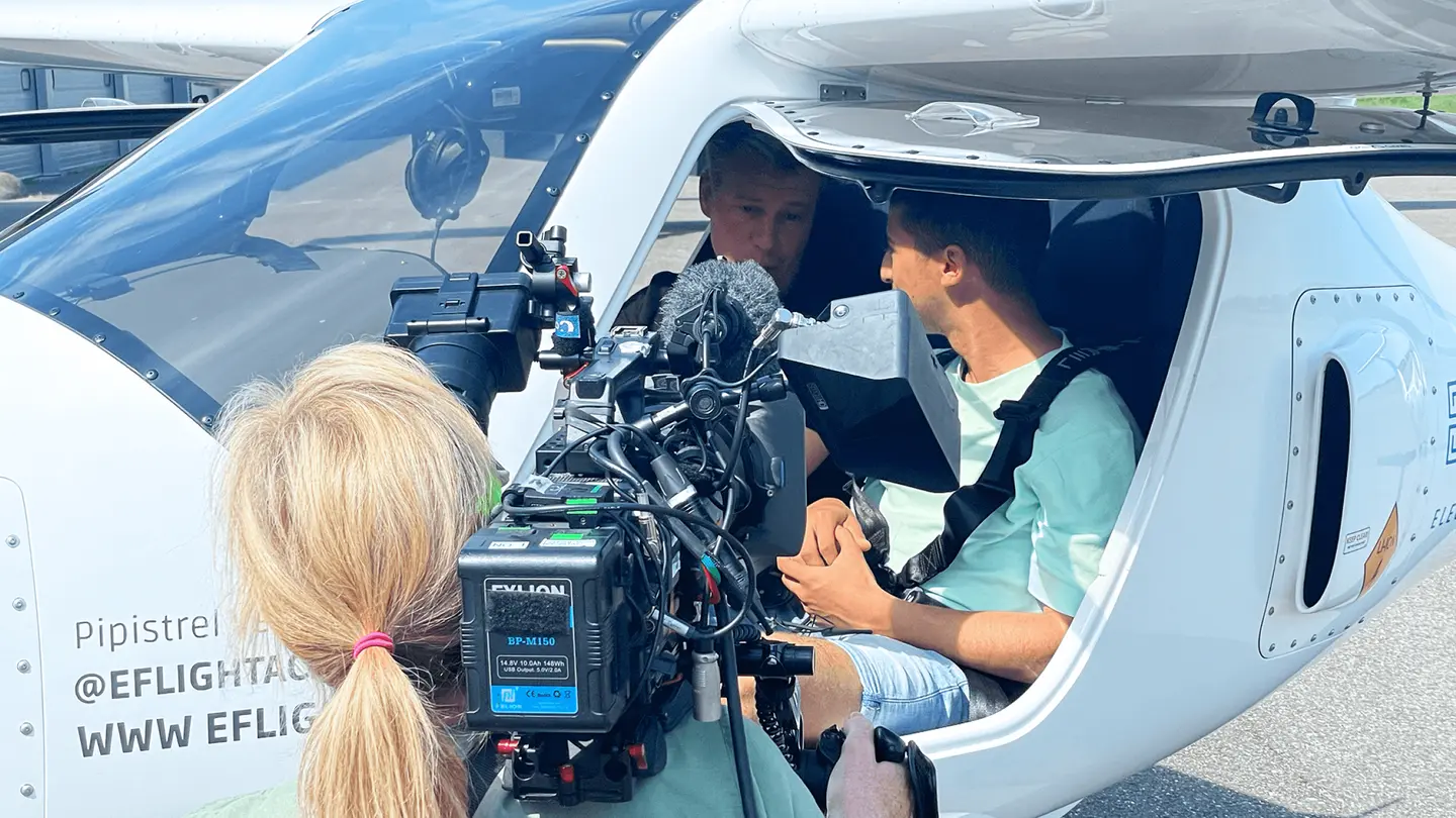 Cameraman filmt een gast in de cockpit van een elektrisch vliegtuig