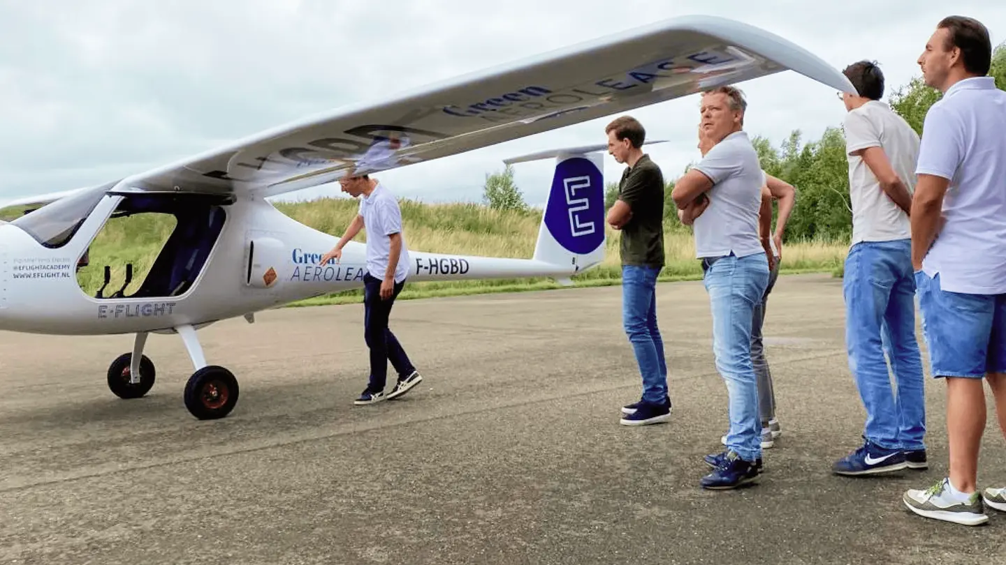 Bezoekers bekijken een elektrisch vliegtuig op het platform