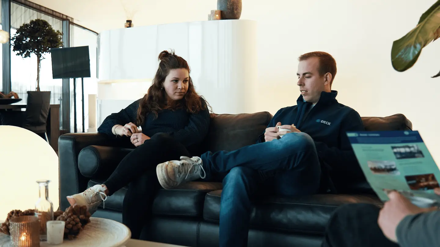 Twee mensen bekijken een brochure op de bank in de lounge van de Sky Lounge