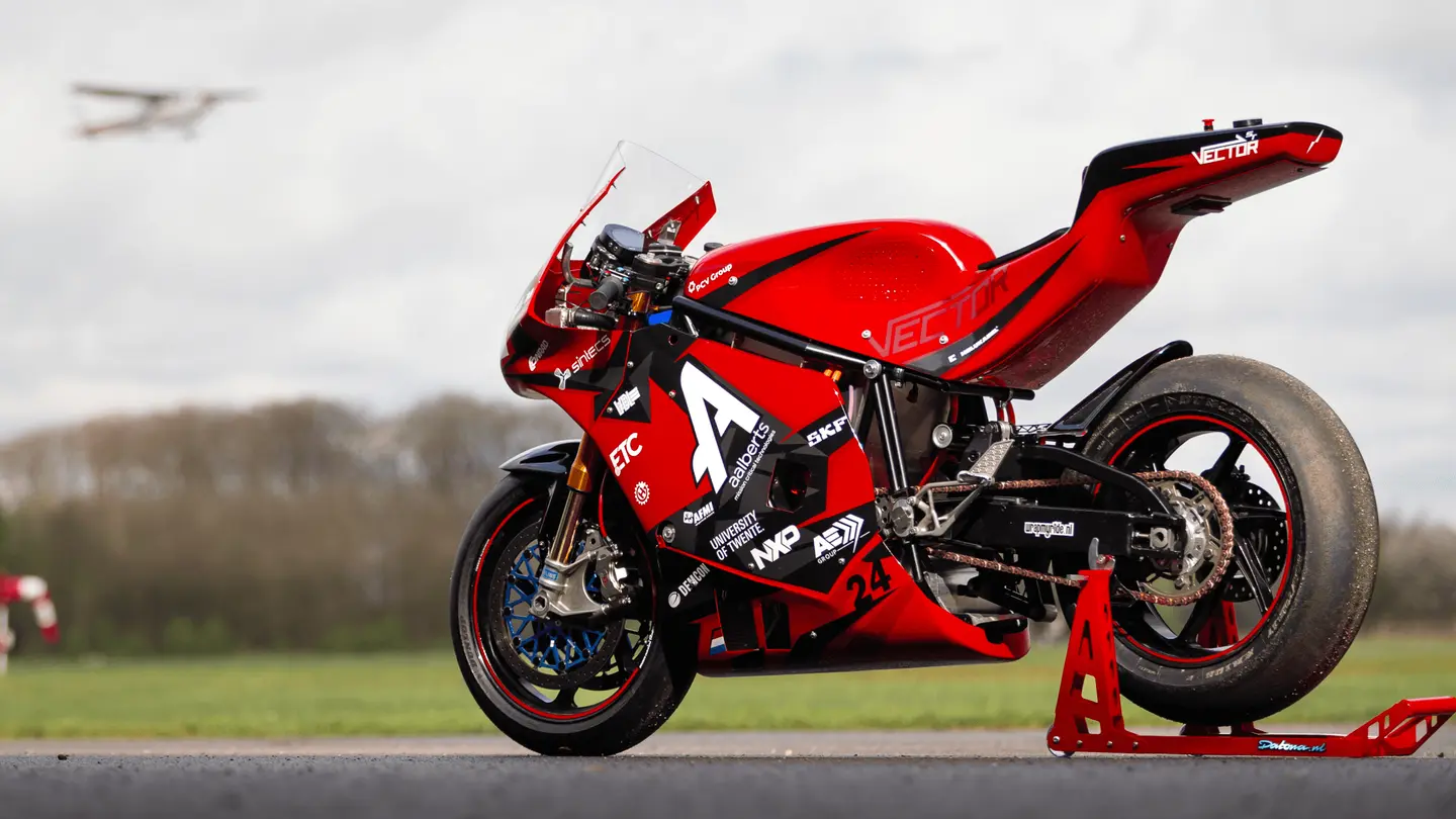 Rode superbike op een standaard op het platform, met een vliegtuig in de lucht