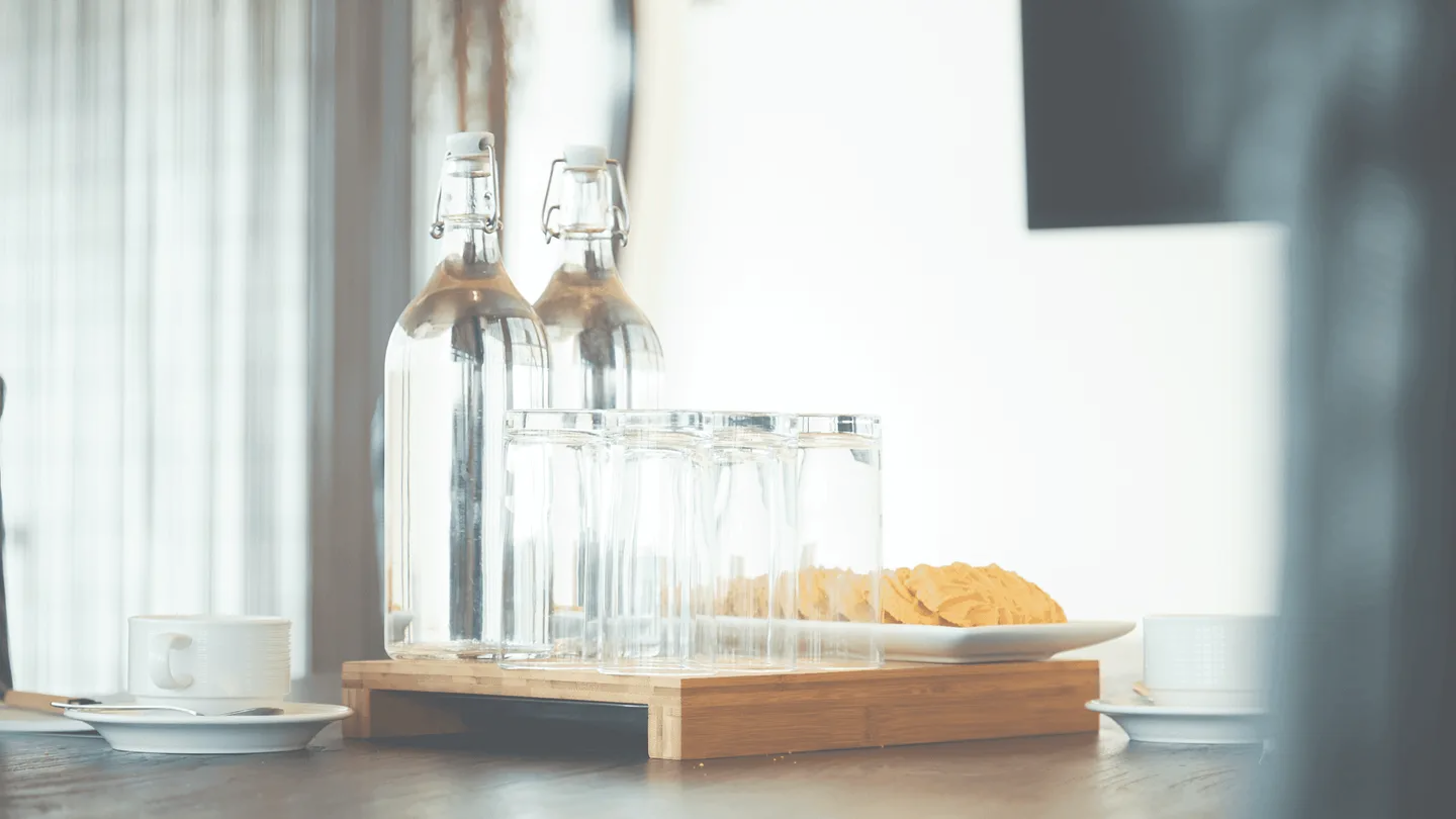 Glazen karaffen en een bord met snacks op een houten plank