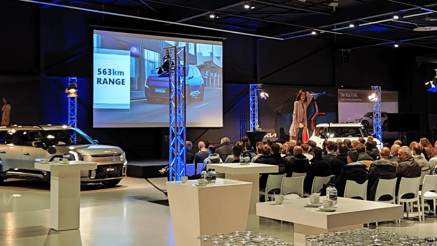 Kia-presentatie in The Hangar met podium, groot scherm en tafels met gasten